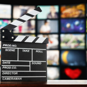 Clapperboard on the background of television screens